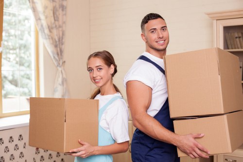 Local movers handling furniture on a residential street in Willesden